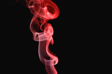 Siyah arka planda kırmızı duman. Renkli duman. Tütsü çubuğu dumanı, kırmızı ışıkla aydınlatılır..