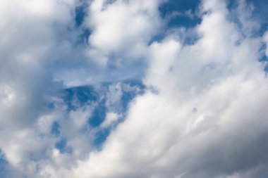 Güneşli bir günde beyaz pamuk bulutları. Yaz gökyüzünde sürekli bir bulut akıntısı.