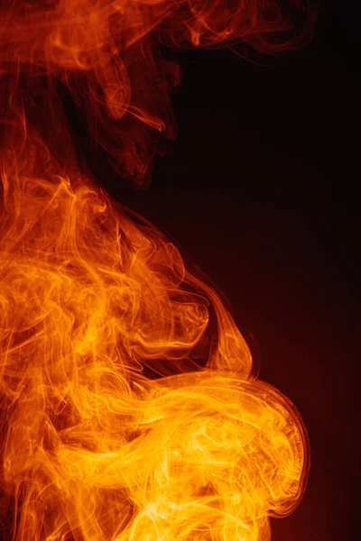 Oranje rook op een donkere achtergrond. Ingewikkelde wervelingen van gekleurde rook. — Stockfoto