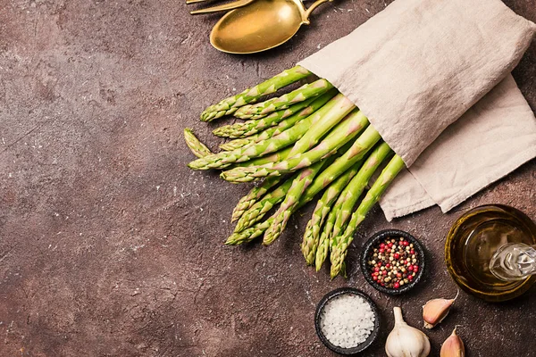 Bunch Fresh Asparagus Spices Olive Oil Brown Stone Background Top — Stock Photo, Image