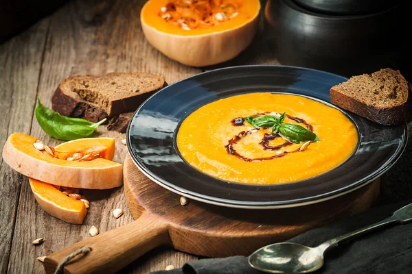 Sopa Calabaza Zanahoria Con Crema Albahaca Plato Negro Sobre Fondo — Foto de Stock