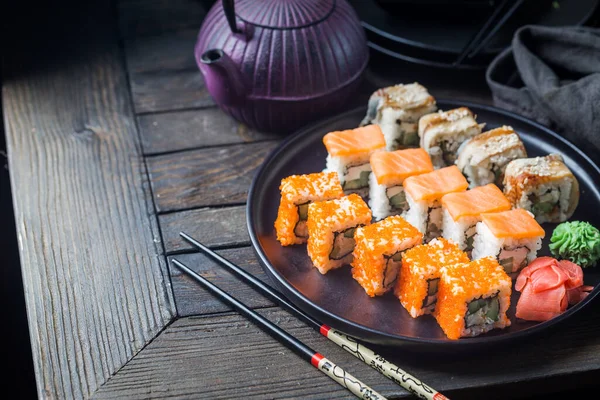 Olika Typer Sushi Rullar Serveras Svart Tallrik Över Mörk Bakgrund — Stockfoto