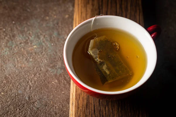 Sachet de thé dans une tasse rouge — Photo