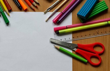 Boş kağıt ile masaya üst görünüm. Metin alanı ile okul konseptine geri dönün. Boya fırçaları, kalem ve plastikine sahip renk boyaları. Çocuk boyama konsepti. Çocuk sanatı.