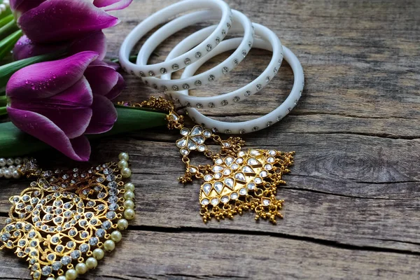 Индийские украшения для танцев: браслеты, ожерелье. Фиолетовые ультрафиолетовые тюльпаны на старом деревенском деревянном фоне . — стоковое фото