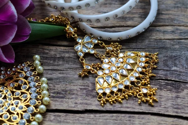 Индийские украшения для танцев: браслеты, ожерелье. Фиолетовые ультрафиолетовые тюльпаны на старом деревенском деревянном фоне . — стоковое фото