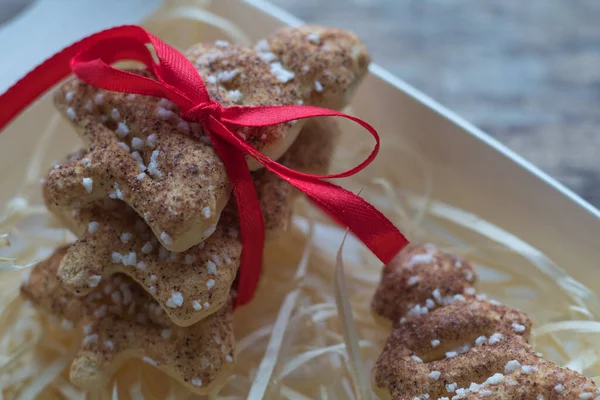 Biscotti di pan di zenzero di Natale in una confezione regalo con nastro di raso rosso, cannella, anice, cardamomo e spezie di chiodi di garofano su sfondo lavagna con spazio per il testo — Foto Stock