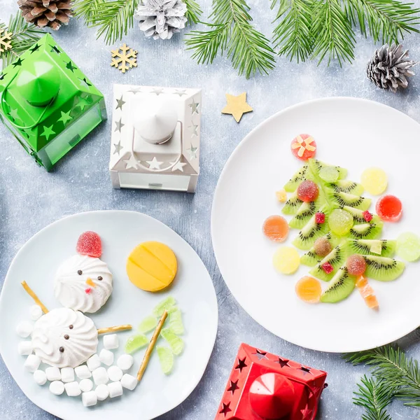 Christmas food for children - kiwi Christmas tree, marshmallow snowman, banana Santa Claus.
