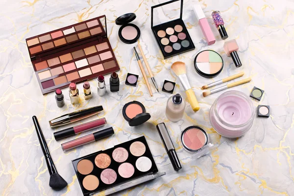 Various makeup products on table, flat design. Woman cosmetic essentials, top view