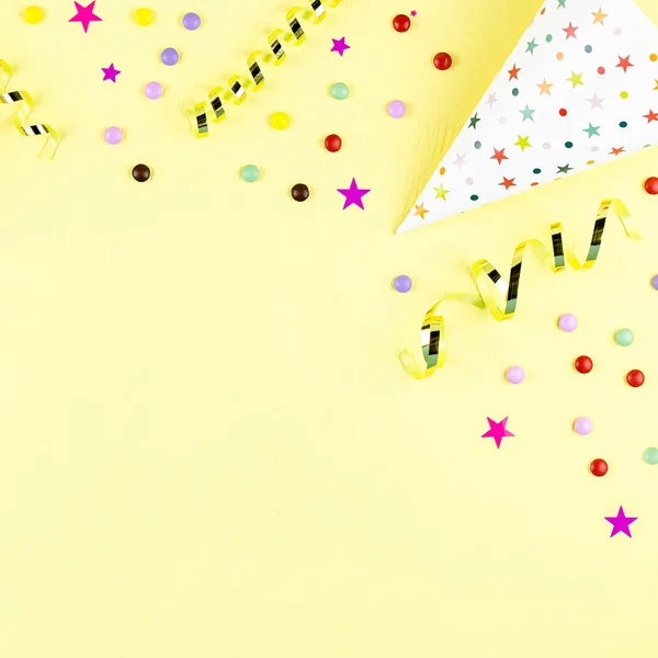 Birthday party background with wrapped gifts, confetti, party hats, decorations, top view