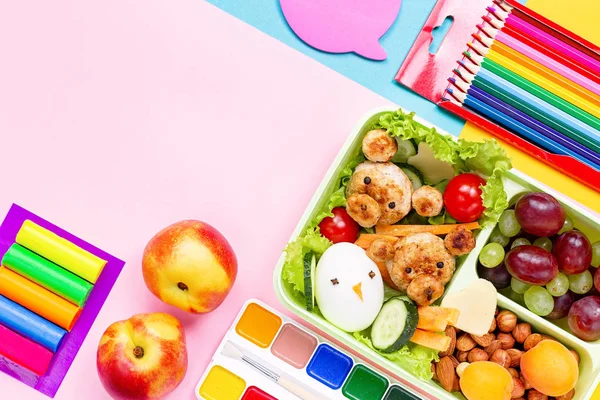 School supplies and lunchbox with food for kids. Colorful stationery layout on multicolor background, copy space