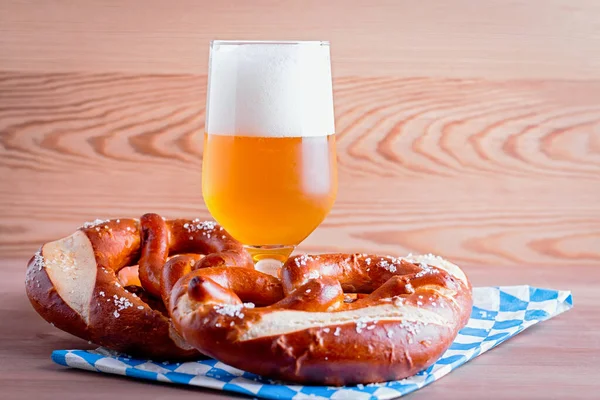 Oktoberfest background with beer and pretzels and traditional bavarian decor closeup on wooden table top
