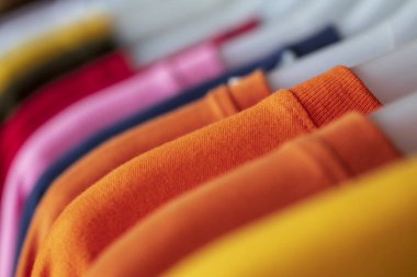 Giysi rafındaki moda kıyafetleri - parlak renkli dolap. Gökkuşağı renk seçimi mağaza dolabında ya da bahar temizliği konseptinde askılarda moda bir kadın giyer. Yazlık kıyafet.