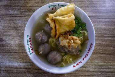 Traditional food of indonesia bakso or meat ball served with noodles and dumplings clipart
