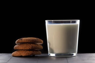 Siyah arka planda kurabiye li süt