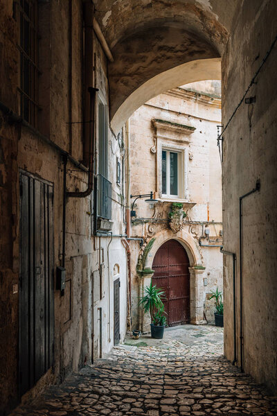 Arch and cobblestone path in Matera, Italy.