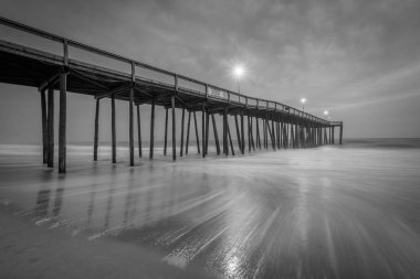 Dalgalar Atlantik Okyanusu ve alacakaranlık, balıkçılık iskelede Ocean City, Maryland.