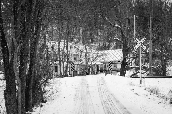 Bridge and railroad crossing along a snow covered country road, in a rural area of Carroll County, Maryland.