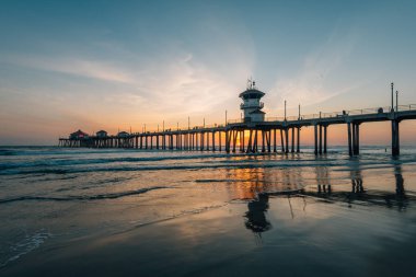 Gün batımı yansımaları ve Huntington Beach, turuncu Coun İskelesi
