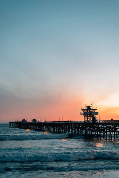 Vlny v Tichém oceánu a molo při západu slunce v San Klement — Stock fotografie