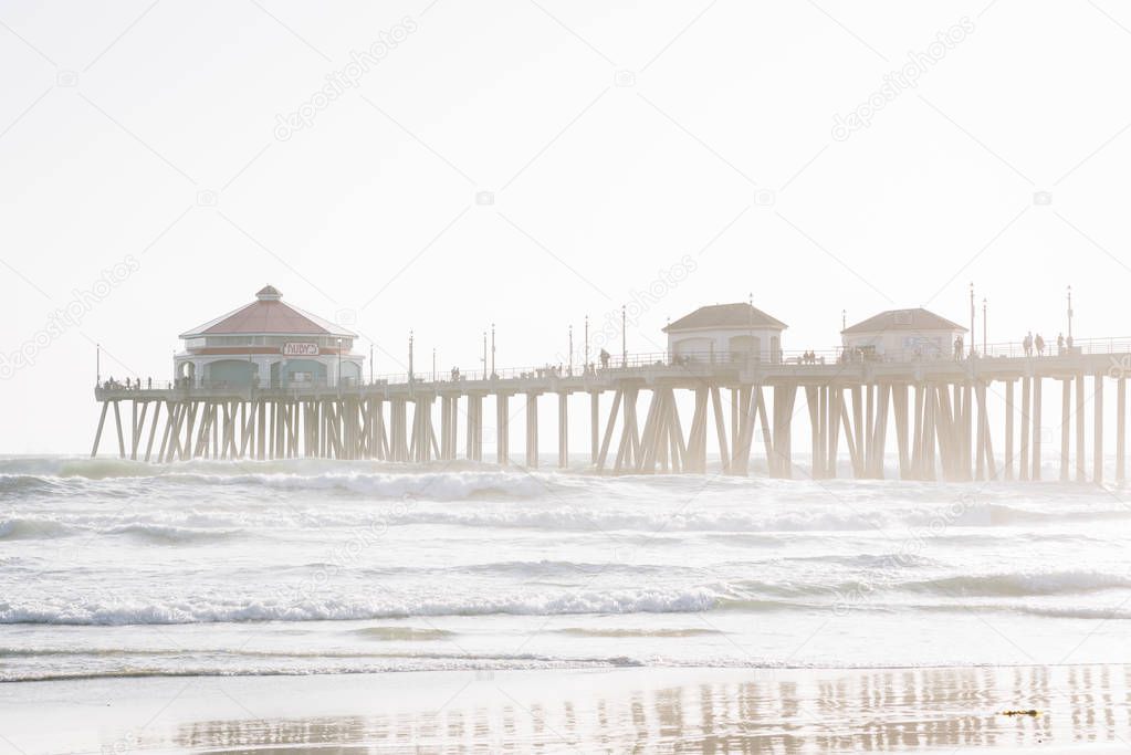 Waves in the Pacific Ocean and the pier in Huntington Beach, Ora