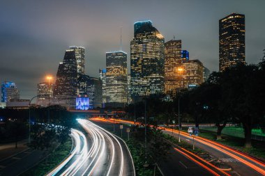 Trafik Allen ağaçlı yol ve Houston skylin uzun pozlama
