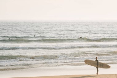 Bir sörfçü Pasifik Okyanusu girer, Newport Beach, Orange Coun