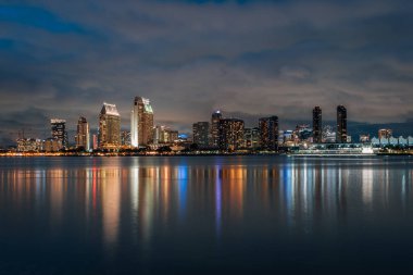 Coronado'dan geceleri San Diego şehir merkezi silüetinin görünümü, 