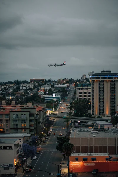 View of First Avenue and an airplane landing in San Diego, Calif