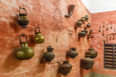 bir duvar üzerinde asılmış görülen pirinç aletleri