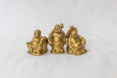Gülen Buddha grubu beyaz bir zemin içinde altın renkte boyanmış. Son derece sığ alan derinliği ile makro konularda seçici odak.