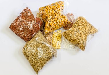 Mısır, Hardal, gram, Mung fasulye, zemin fındık, Kişniş küçük paketler beyaz bir arka plan üzerine yerleştirilir. Konuya seçici bir şekilde odaklanarak.