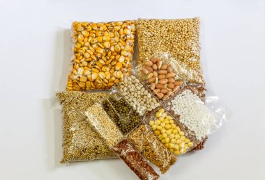 Mısır, Hardal, gram, Mung fasulye, zemin fındık, Kişniş küçük paketler beyaz bir arka plan üzerine yerleştirilir. Konuya seçici bir şekilde odaklanarak.
