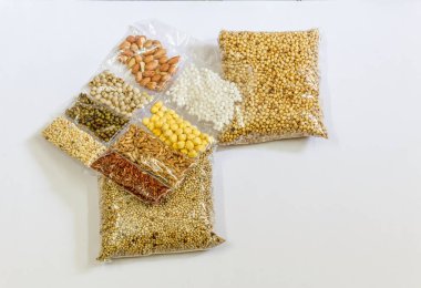 Mısır, Hardal, gram, Mung fasulye, zemin fındık, Kişniş küçük paketler beyaz bir arka plan üzerine yerleştirilir. Konuya seçici bir şekilde odaklanarak.