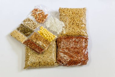 Mısır, Hardal, gram, Mung fasulye, zemin fındık, Kişniş küçük paketler beyaz bir arka plan üzerine yerleştirilir. Konuya seçici bir şekilde odaklanarak.