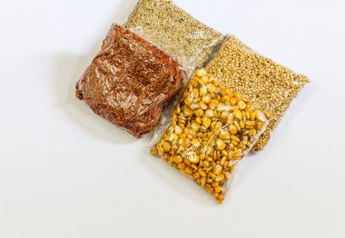 Mısır, Hardal, gram, Mung fasulye, zemin fındık, Kişniş küçük paketler beyaz bir arka plan üzerine yerleştirilir. Konuya seçici bir şekilde odaklanarak.