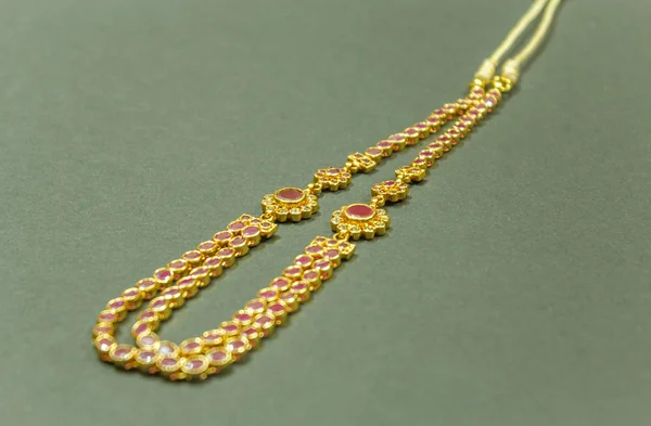 Gold chain with red ruby stones.With selective focus on the subject.