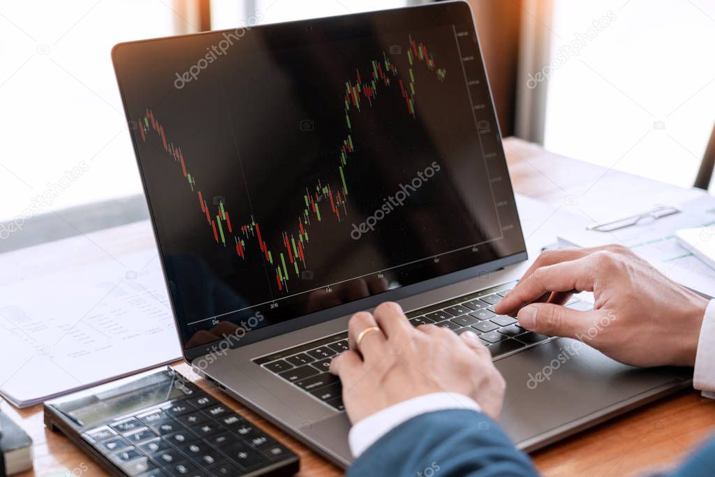 businessman or broker looking at computer laptop analysing about