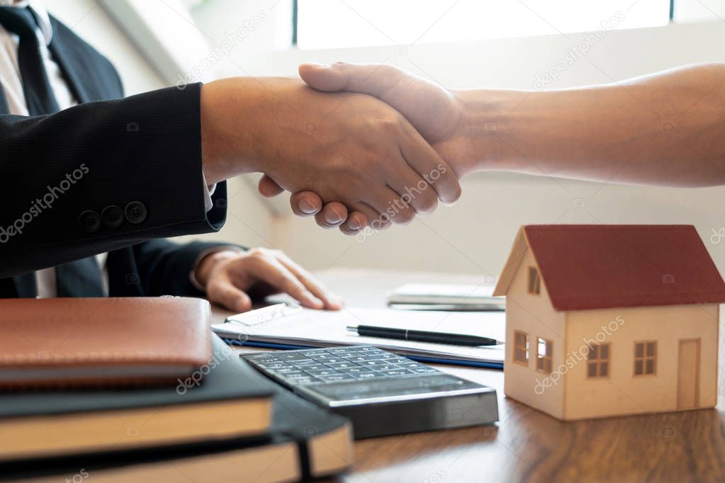 Customer and broker shake hands agreeing to buy new house at mee