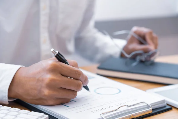 Primer plano de las manos Empresario leyendo y escribiendo con bolígrafo signi — Foto de Stock