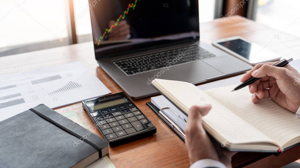 businessman or broker looking at computer laptop analysing about