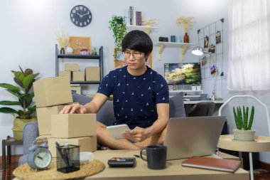 Küçük işletme kurun Asyalı genç girişimci paket paketleme karton kutu teslimat işlemi için ana ofis, çevrimiçi pazarlama müşteri göndermek için
