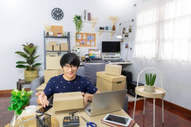 Küçük işletme kurun Asyalı genç girişimci paket paketleme karton kutu teslimat işlemi için ana ofis, çevrimiçi pazarlama müşteri göndermek için