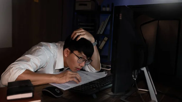 Feeling exhausted or Tired businessman working late on computer at office late in the evening night headache bad vision sight problem touching his forehead, stressful life and deadlines concept
