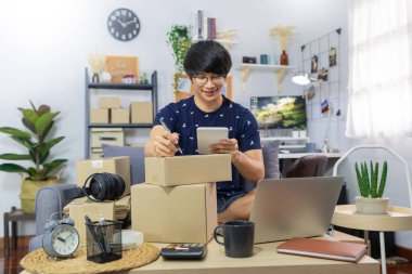 Girişimci KOBİ ya da serbest çalışan kişi siparişi ve yazma paketini bir karton kutuya koyup teslimat ve çevrimiçi alışveriş konseptine hazırlar