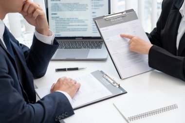 Genç iş kadını, şirketteki insan kaynakları yöneticilerine iş başvurusunda bulunan kişilerle yaptığı görüşmede profilini açıklıyor ve özgeçmişini tutuyor..