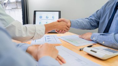 Asyalı iş adamı sigorta komisyoncusu veya finans danışmanı genç milenyum çifti müşterilerine yatırım için danışıyor