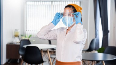 Çekici Asyalı garson restoranında virüs salgınını korumak için yüz maskesi takıyor ve yüz maskesi takıyor. Coronavirus hastalığı COVID-19, yeni normal kavram.