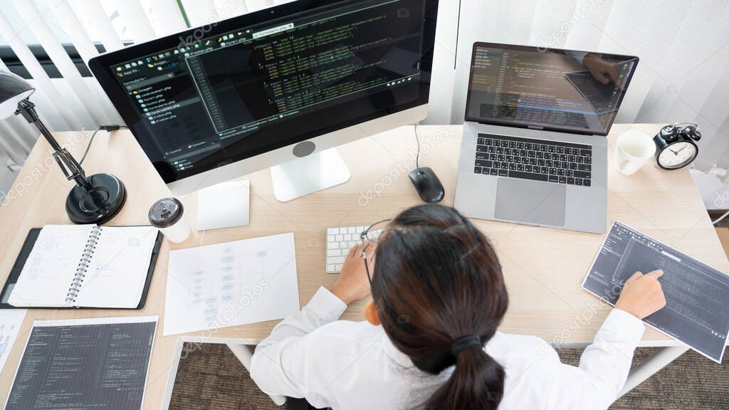 Young Asian woman Programmer Typing code working with computer at table, coding cyberspace and Web Development Concept.