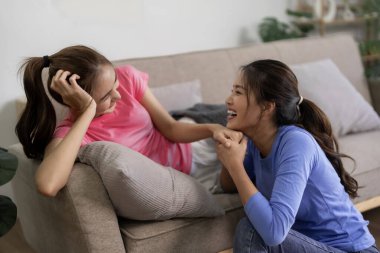 İki mutlu Asyalı kadın birlikte hassas anlarından zevk alır. Evlerini rahatlatır. Otantik sevgi bağı, neşeli yakınlık.